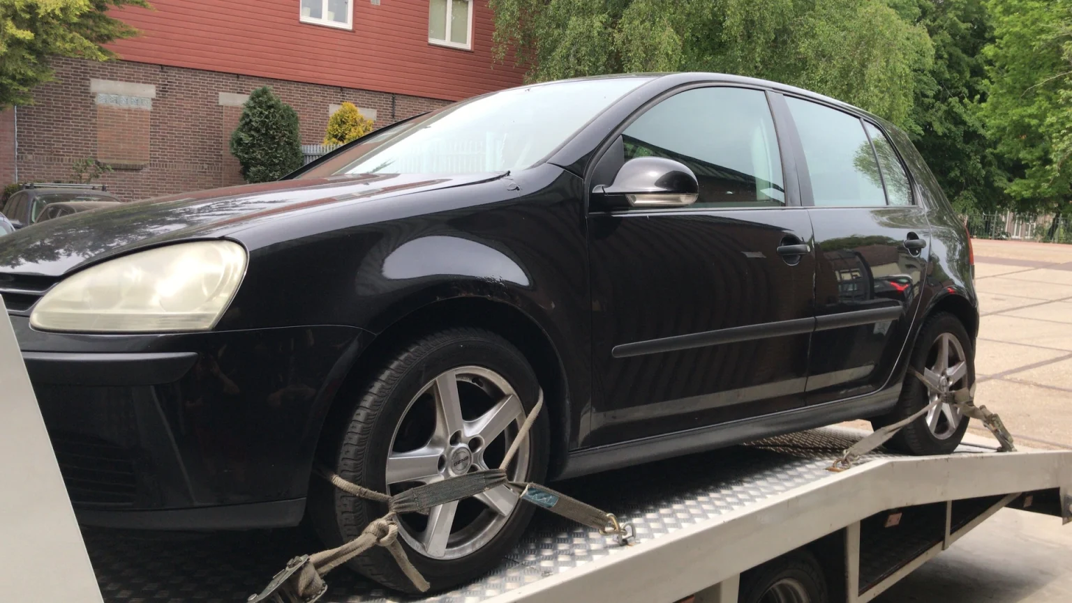 Een zwarte Auto verkocht aan auto inkoop amsterdam en opgeladen op een oplader